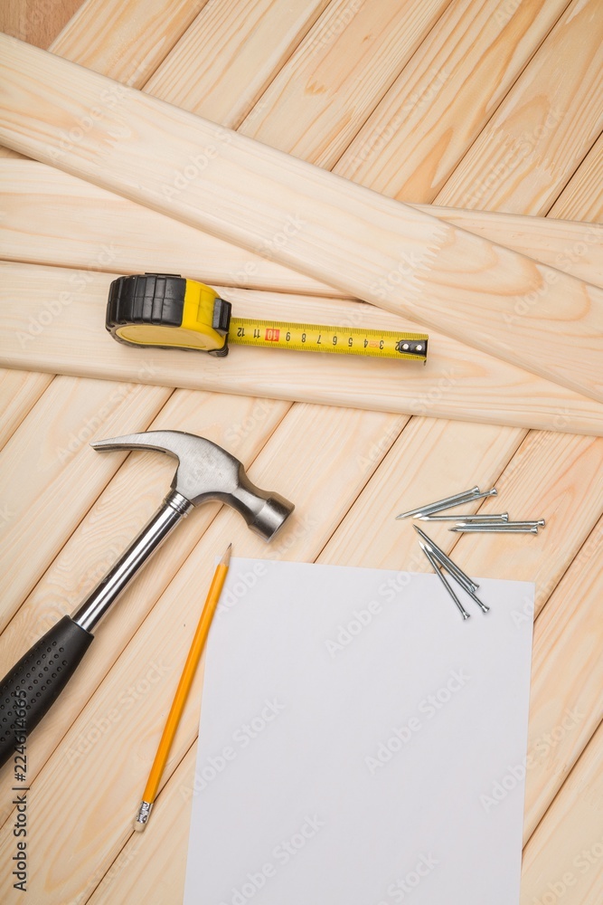 Hammer and nails on wood with measuring tape