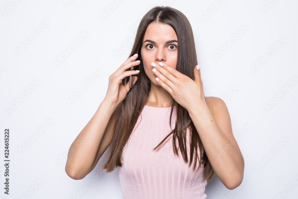 Close up portrait of shocked woman talking to somebody on the phone on white background Close up portrait of shocked woman talking to somebody on the phone on white background