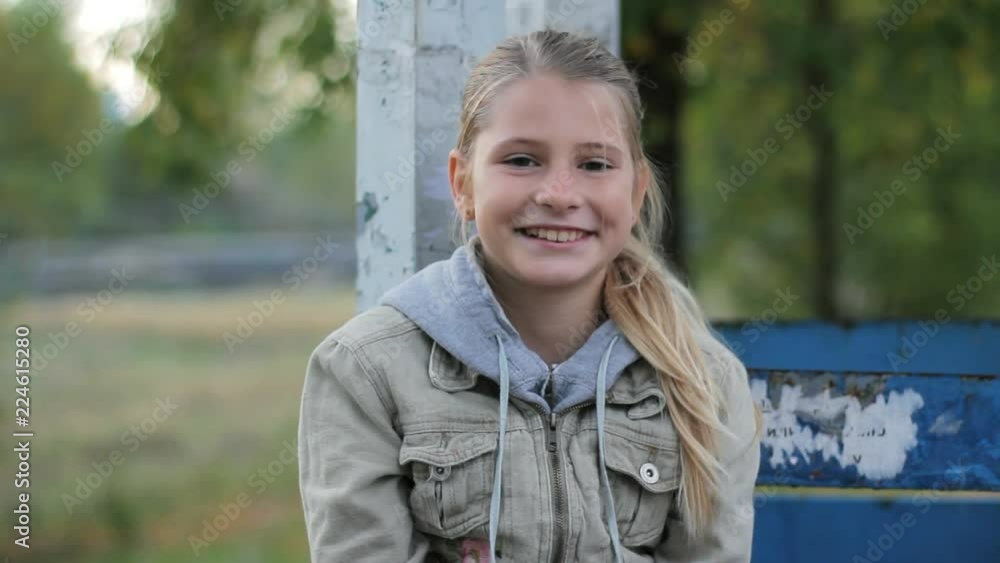 Portrait of blonde preteen girl smiling and laughing at camera in suburbs Portrait of blonde preteen girl smiling and laughing at camera in suburbs
