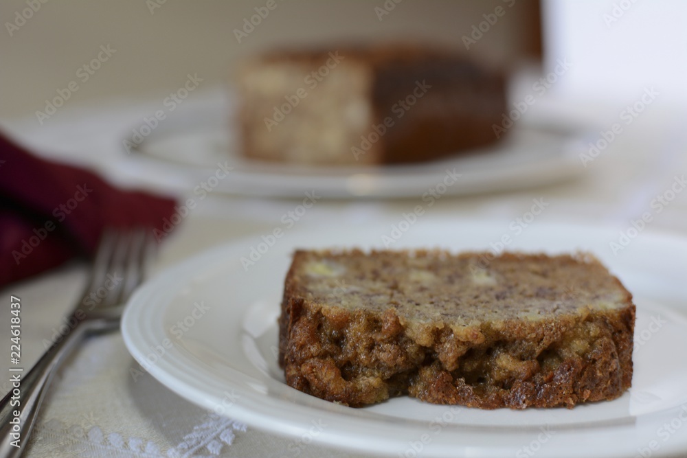 Baked gluten free banana bread on a white plate sitting on a table