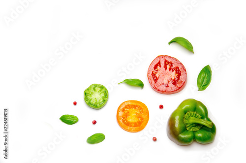 sliced vegetables tomato and pepper and paprika and salad and Basil and pepper peas on white background 
