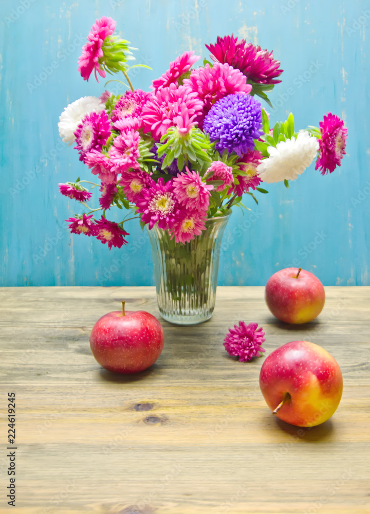 bouquet of garden flowers in a vase on a wooden table and apples bouquet of garden flowers in a vase on a wooden table and apples