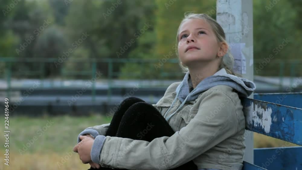 Cute preteen girl sitting alone hugging her knees ...  