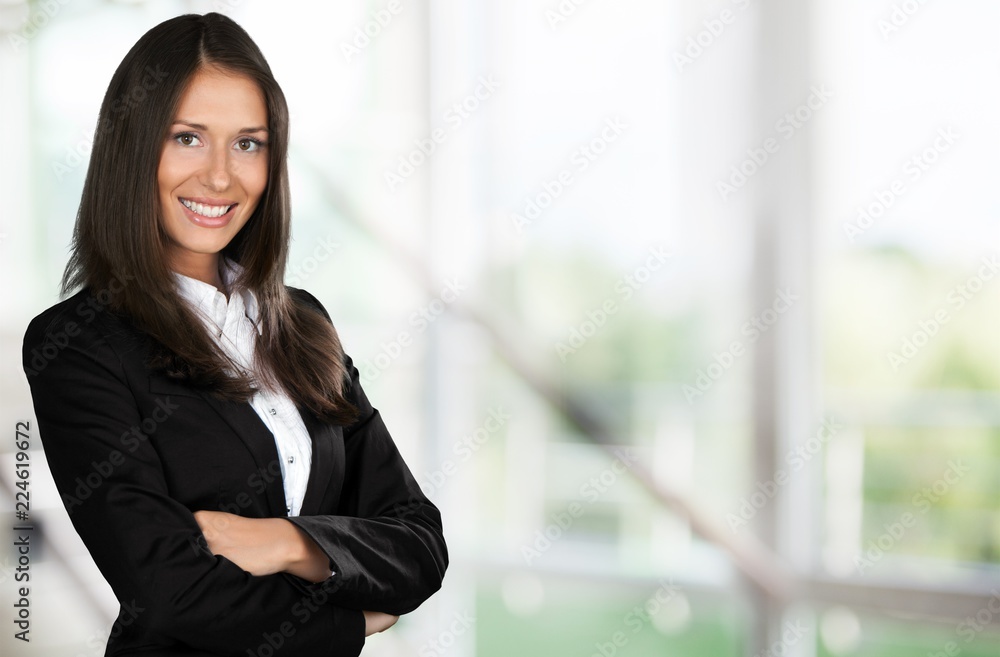 Businesswoman with crossed arms smiling at camera Businesswoman with crossed arms smiling at camera