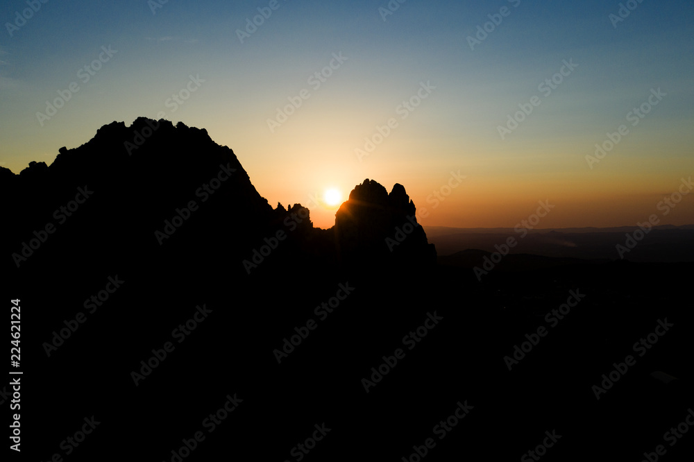 Aerial view of a spectacular sunset behind some rocky mountains in Sardinia, Italy.