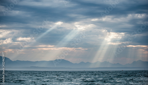 Seascape. Clouds sky. The rays of the sun through the clouds in the dawn sky, Silhouettes of Mountains on the Horizon. False bay. South Africa.