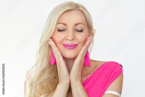 Billede på lærred A beautiful young blonde with closed eyes and a smile, is holding hands by the face