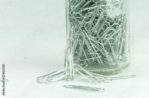 transparent glass container with papperclips white blackgroud