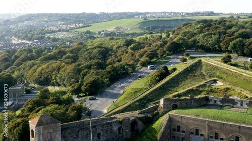 High Angle-Traffic flows flows around the bend of Harold's Road where it becomes Godwin Road below the verdant walls of the Dover Castle on the coast of England at the Dover Straits. photo