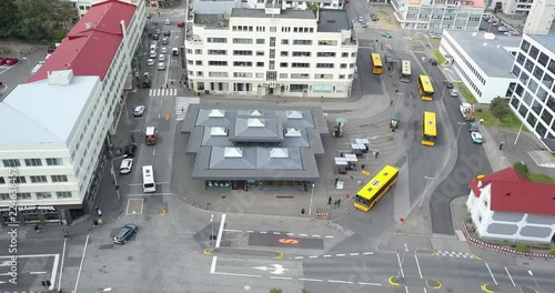 Bus station in Reykjavik. Three yellow buses arrive and leave. photo