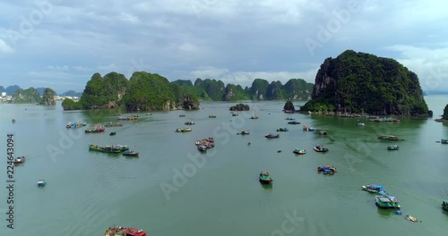 4k Aerial Over boats docked in bay with karst mountains. Ha long bay. Halong City, Vietnam photo