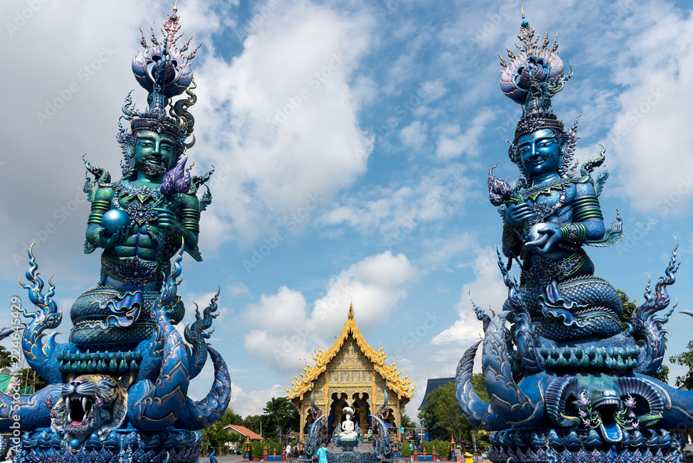 Colorful ornamental exterior of Wat Rong Suea Ten (also known as Blue Temple) with beautiful design against blue sky, Chiang Rai