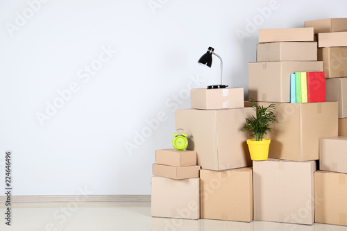 Cardboard boxes with household stuff on grey background © 5second