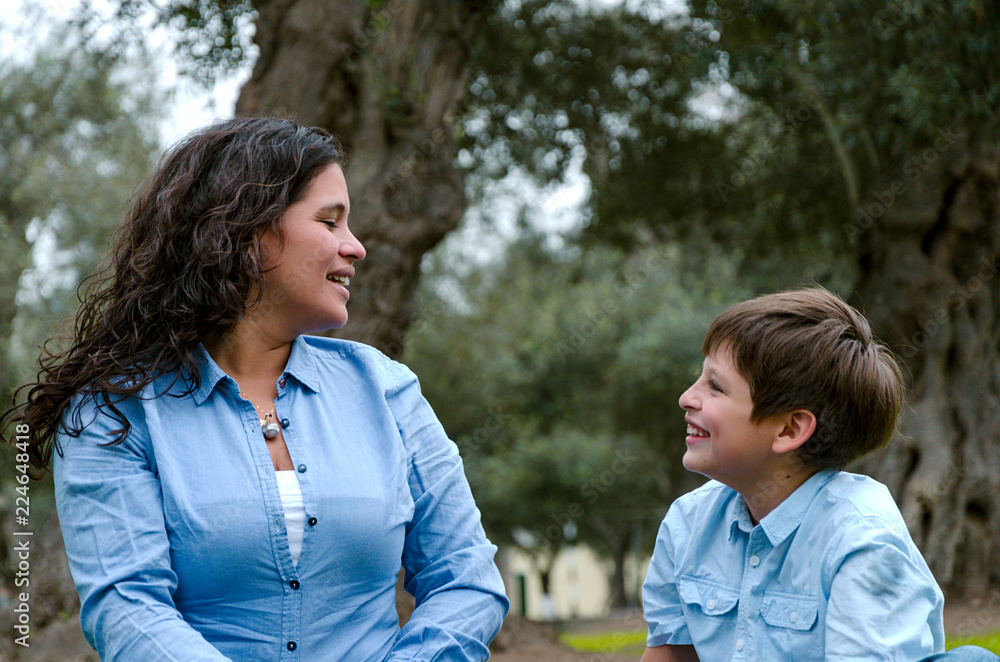 Beautiful woman and her cute little son looking at each other laughing Beautiful woman and her cute little son looking at each other laughing