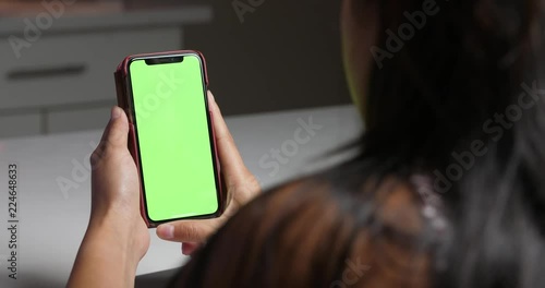 Woman holding green screen smartphone
