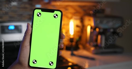 Woman holding green screen smartphone