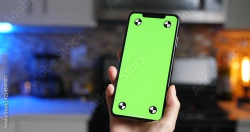 Woman holding green screen smartphone