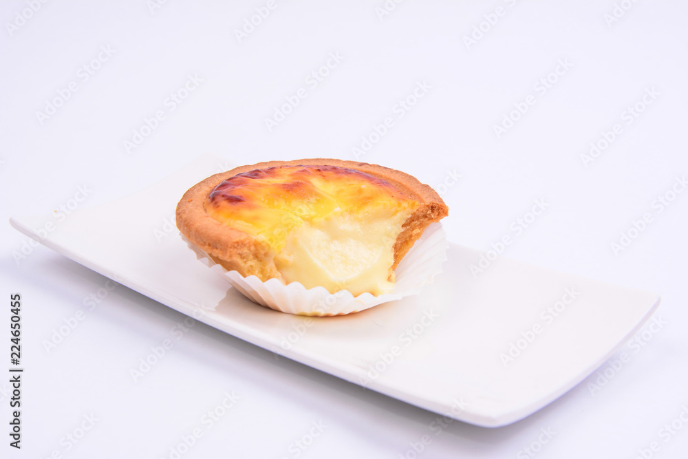 Half eaten cheese tart pastry in a white ceramic plate isolated on white background. Half eaten cheese tart pastry in a white ceramic plate isolated on white background.
