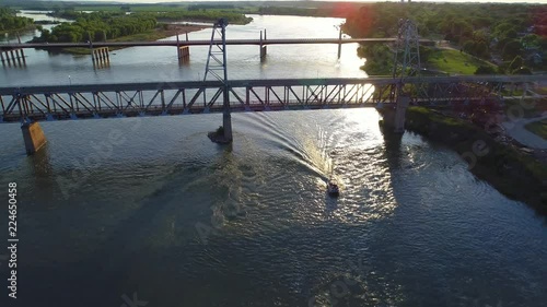 Boat going under a bridge at sunset in 4K photo