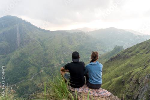 Travel concept. Couple sitting on top of Small Adams peak near Ella, Sri Lanka