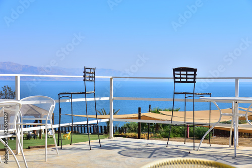 240 meters below sea level, the lowest place on the planet, view of the Dead Sea, fences, tables and chairs in the foreground, cloudless sky © Nemo67