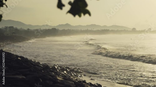 Big tide waves coming from the ocean and spashing on the rock shores of Pantai Lebih in Indonesia photo