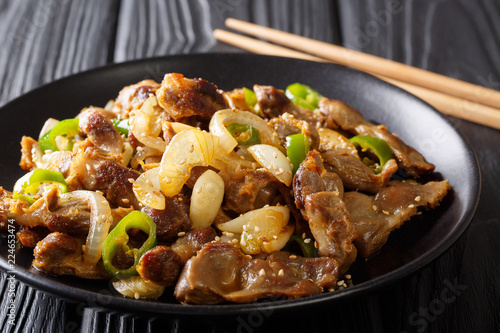 Traditional Korean spicy chicken gizzard with onions, garlic, chili and sesame close-up. horizontal