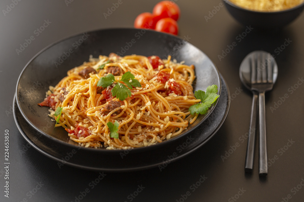 Delicious spaghetti with Bolognese sauce served on a black plate Delicious spaghetti with Bolognese sauce served on a black plate