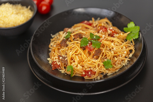 Delicious spaghetti with Bolognese sauce served on a black plate