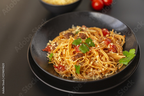 Delicious spaghetti with Bolognese sauce served on a black plate