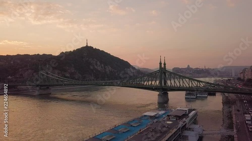 aerial drone footage of the liberty brindge in budapest at sunset with thee gell  rt hill in the background photo