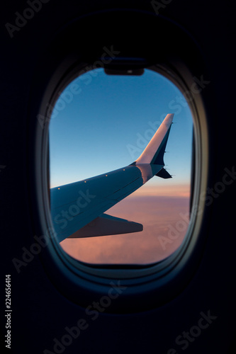 Wing of an airplane as seen through the aircraft window.