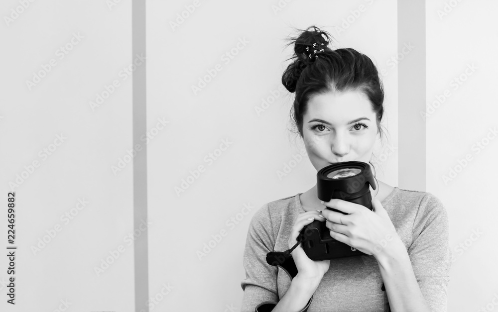 Pretty girl photographer kisses her camera and smiles, black and Pretty girl photographer kisses her camera and smiles, black and
