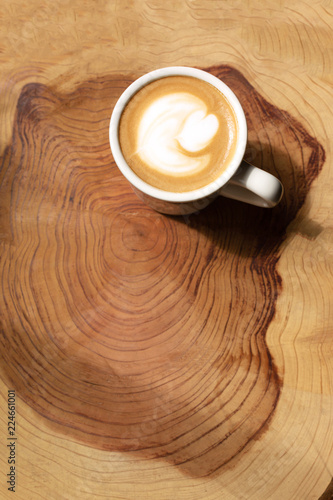 Cup of coffee on the piece of wood