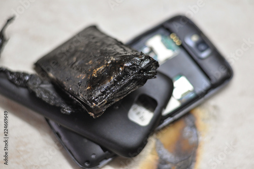 Mobile phone battery explodes and burns due to overheat. Danger, exploded mobile phone battery