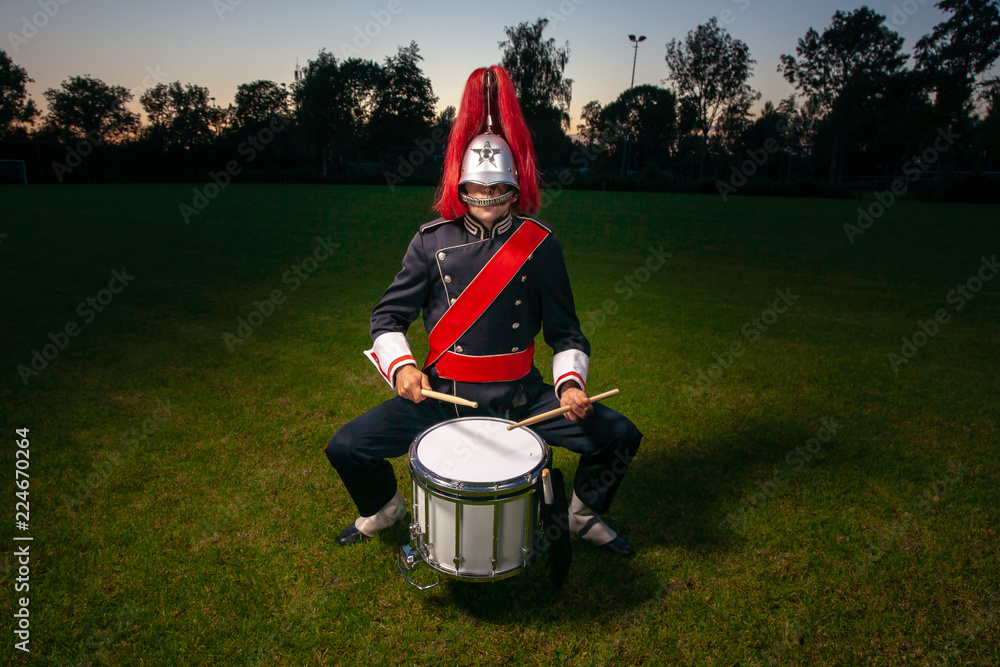Φωτογραφία Cool portrait of musician in uniform with atmospheric light on a green grass fie