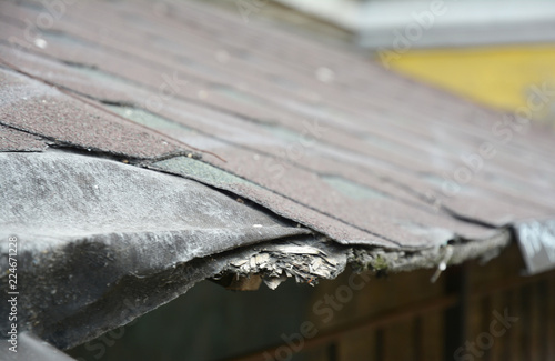 Asphalt shingles damage. Fixing damaged roof shingles.
