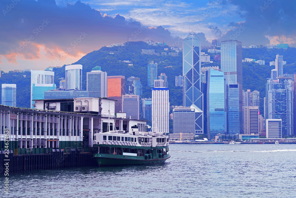 Hong Kong city skyline view at dusk with ferry pier.