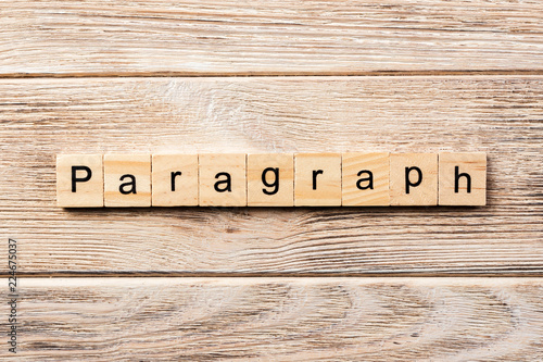 paragraph word written on wood block. paragraph text on table, concept