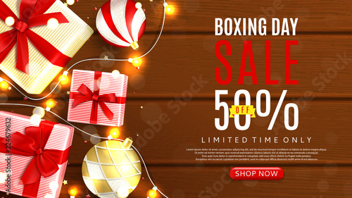 Boxing day sale web banner template. Top view on realistic gift boxes and Christmas balls on rustic wooden texture. Vector illustration with confetti and effect bokeh.