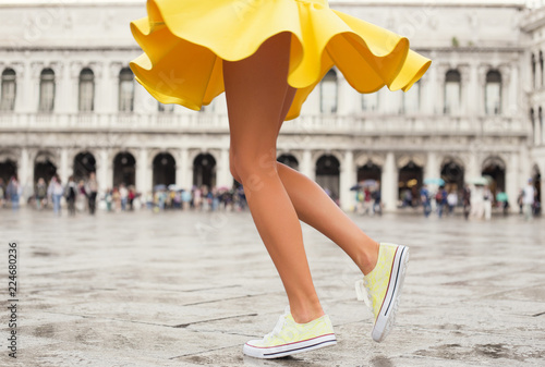 Happy woman in bright yellow skirt and sneakers