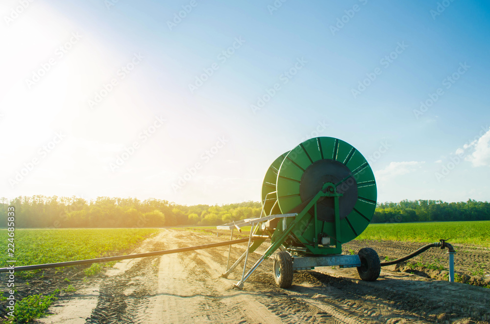 Irrigation system for watering of agricultural crops with a big hose reel.  Industrial equipment for irrigation. Agriculture, farming. big spools of  water pipes to irrigate the fields Stock-Foto | Adobe Stock