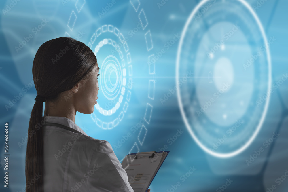 Abstract health care and medical engineering concept. A woman health care professional, or scientist, or bio engineer, is using a futuristic, innovative technology holographic machine Abstract health care and medical engineering concept. A woman health care professional, or scientist, or bio engineer, is using a futuristic, innovative technology holographic machine