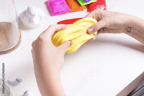 Girl hands playing with yellow slime