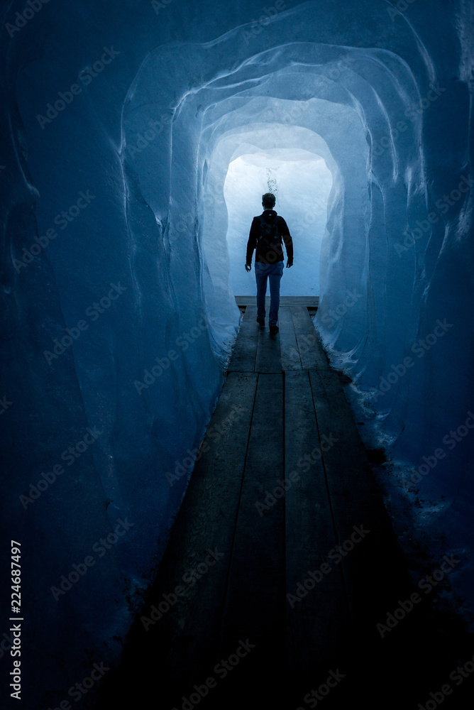 Silhouette of a man walking through a ice tunnel