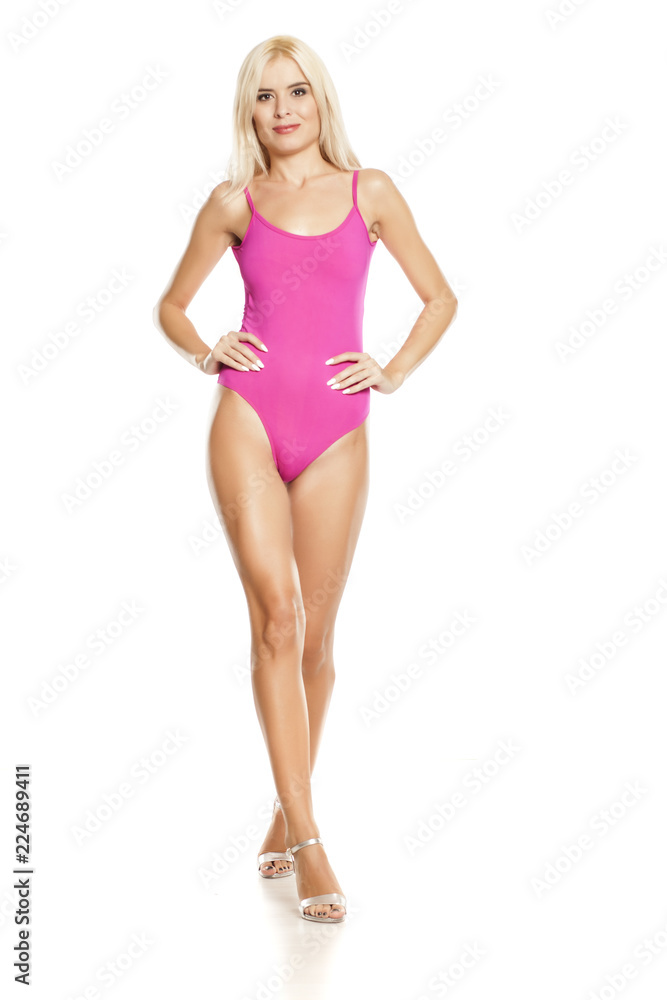 young pretty blonde woman walking in pink sweamsuit on white background young pretty blonde woman walking in pink sweamsuit on white background