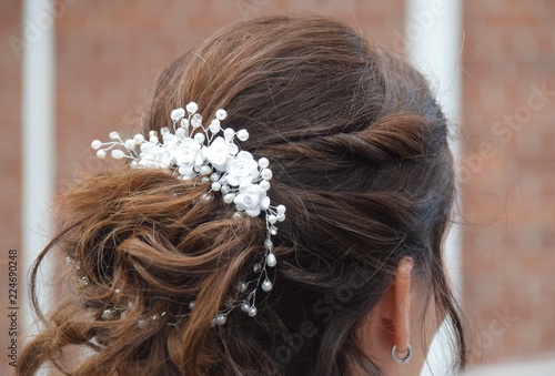 Kunstvolle, hochgesteckte Frisur einer Braut mit weißen Haarspangen