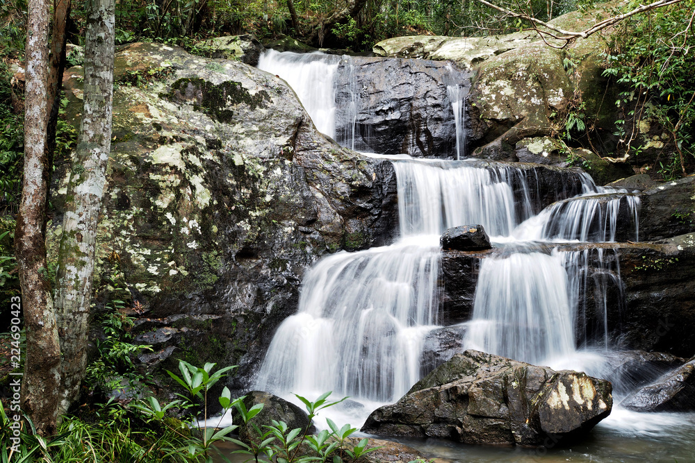 Obraz premium Mountain river background with small waterfalls in tropical forest.