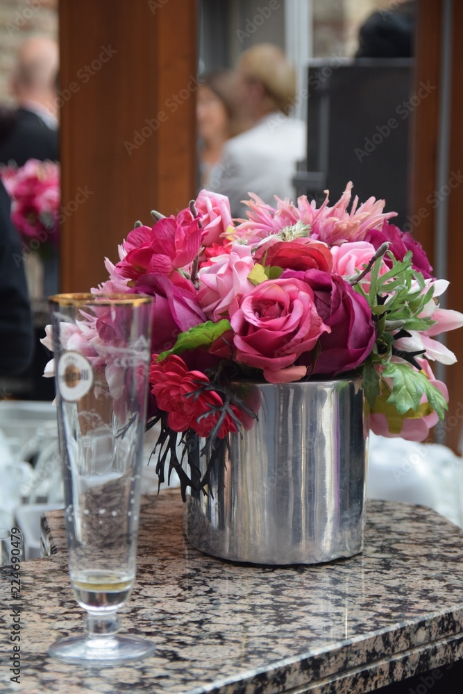 Fototapeta premium Blumenstrauß mit roten und pinken Rosen auf einem Tresen