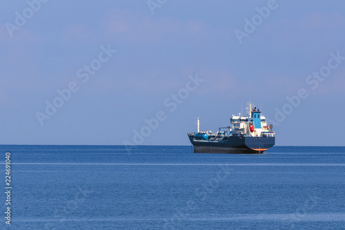sea cargo ship at sea against  a background of the sea horizon  and a cloudless sky